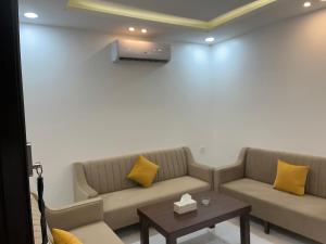 a living room with two couches and a table at الغاف للشقق المخدومة in Sarat Abidah
