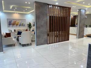 a lobby with a waiting room with tables and chairs at الغاف للشقق المخدومة in Sarat Abidah