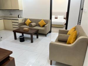 a living room with two couches and a coffee table at الغاف للشقق المخدومة in Sarat Abidah