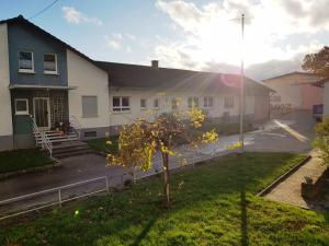 a white house with a tree in the yard at Apartment Terrasse in Gau-Weinheim