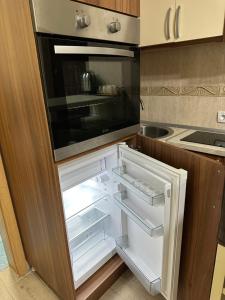 an empty refrigerator with its door open in a kitchen at Imperija in Kragujevac