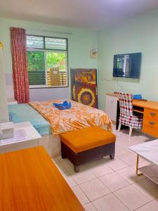 a bedroom with a bed and a desk and a window at Nan Inn Bungalow in Karon Beach