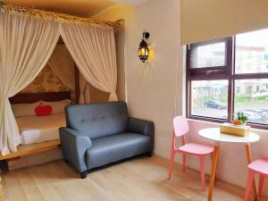 a bedroom with a bed and a chair and a table at 墾丁巴里巴里 in Kenting