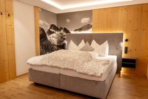 una camera da letto con un grande letto bianco in una stanza di Eggerstüberl a Ischgl