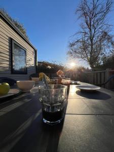 una mesa con un vaso de agua encima en MobilHomeTorreilles, en Torreilles