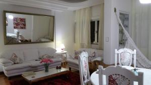 Una sala de estar con un sofá blanco y sillas. en Apartamento Salvador VIP, en Salvador