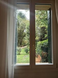 una ventana abierta con vistas al jardín en Garden Lodge by Veneto Villa, en Villa Osti