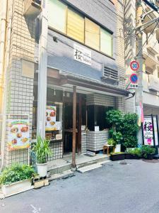 a store front of a building with plants in front at Osaka Guesthouse Sakura in Osaka