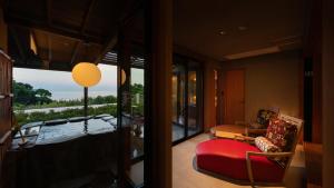 a living room with a red couch and a large window at Isaribi (No Children) in Higashiizu +84 photos