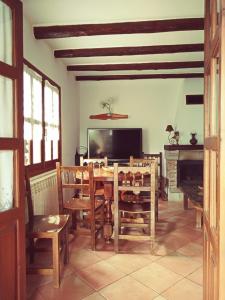 a dining room with a table and a television at La Simona Casa Rural in Perales del Puerto +40 photos