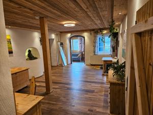 a room with a hallway with a wooden ceiling and a table at Premium Apartment mit privatem Whirlpool, Sauna, Garten in Sankt Martin am Grimming +13 photos