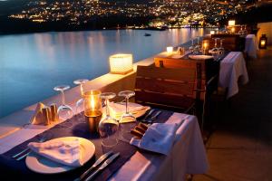 a table with plates and wine glasses and a view of the water at Hotel Villa Mahal in Kalkan