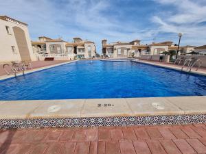 a large swimming pool in front of some houses at La Casa de Torrevieja in Torrevieja