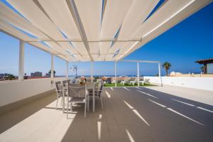 a table and chairs on the roof of a building at Villa La Laja with 5 bedrooms and sea view in Callao Salvaje