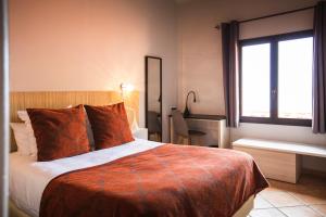 a hotel room with a bed and a window at Le Relais Des Trois Mas in Collioure