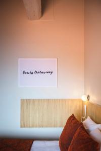 a sign on the wall of a room with a bed at Le Relais Des Trois Mas in Collioure