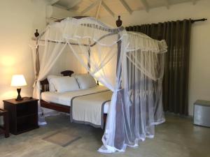 a bedroom with a canopy bed in a room at The Horizon Hill Top Villa in Unawatuna