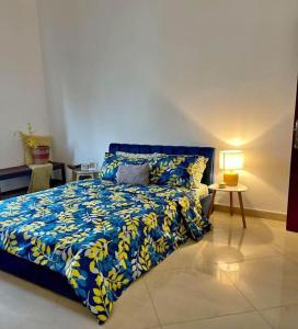 a bedroom with a bed with a blue and yellow bedspread at Rama Rooms in Abu Dhabi