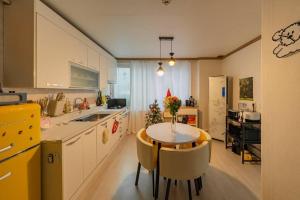 a kitchen with a small table and a yellow refrigerator at Anime House in Daejeon