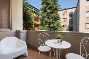 a balcony with two tables and chairs and a tree at Primopiano - Bonghi B in Milan