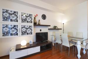 a living room with a table and chairs and a television at Primopiano - Bonghi B in Milan