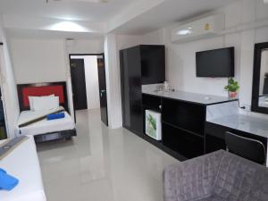 a living room with a tv and a couch in a room at Boomerang Inn in Patong Beach