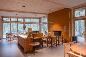 a living room with tables and chairs and a fireplace at Youza ecolodge cabanes dans les arbres in La Couture-Boussey