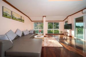 a living room with a couch and a tv at 3 plus 1BR Ocean Breeze Villa 'Brad House Patong' in Patong Beach
