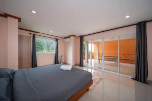 a bedroom with a bed and a large window at 3 plus 1BR Ocean Breeze Villa 'Brad House Patong' in Patong Beach