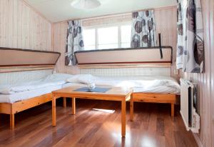 a room with two beds and a table in it at Kvibergs Stugor - Cottages in Gothenburg +11 photos