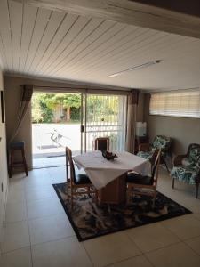a dining room with a table and chairs and a large window at African Kingdom Guest House in Boksburg