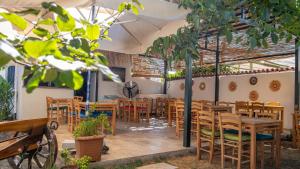 a restaurant with wooden tables and chairs at Tetka Konukevi in Ayvalık
