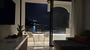 a living room with a view of the ocean at night at Cura Marina Premium in Mogán +40 photos