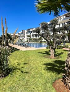 un patio del complejo con piscina y palmeras en Les crêtes dar bouazza, en Casablanca
