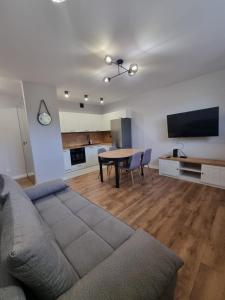 un salon avec un canapé et une table dans l'établissement Przytulne mieszkanie z balkonem dostęp na kod, à Radom
