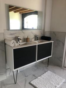 a bathroom with a sink and a mirror at Labastilac chambre plume in Garganvillar +10 photos