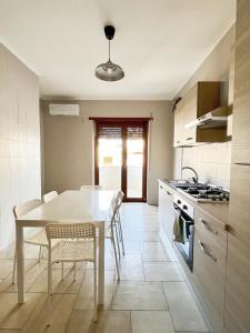 cocina con mesa blanca y sillas en La terrazza, en Castellammare di Stabia
