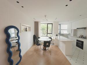 a kitchen with a table with chairs and a mirror at Eastern Hub - Bund Branch Designer Open Kitchen Super Large Sofa Deluxe Three Room in Shanghai