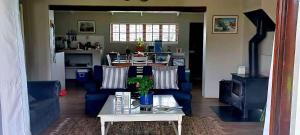a living room with blue couches and a table at Babylons Tower Cottage in Caledon
