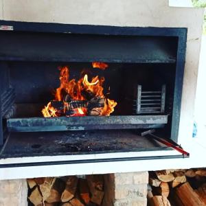 a fire in a brick oven with flames at Babylons Tower Cottage in Caledon