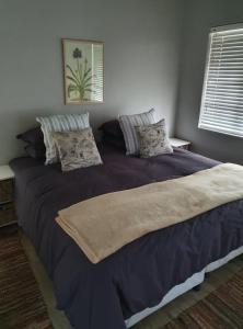 a bedroom with a large bed with purple sheets and pillows at Babylons Tower Cottage in Caledon