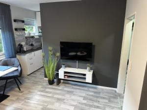 a living room with a tv and a white table at Stadt-Apartment in Bremerhaven +2 photos