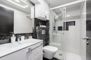 a bathroom with a toilet sink and a shower at Luxury Copacabana in Costa de Adeje