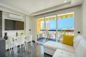 a living room with a white couch and a table at Luxury Copacabana in Costa de Adeje