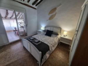 a bedroom with a bed and a large window at Casa Arriba Village House in Zarra in Zarra