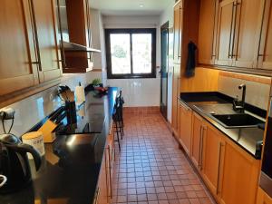 a kitchen with wooden cabinets and a tile floor at Las Salinas in Estepona
