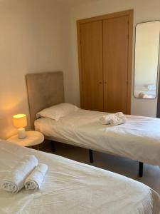 a bedroom with two beds and a chair and a window at Las Salinas in Estepona +15 photos