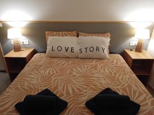 a bed with a pillow with the word love story on it at Gite Happy Sun Flower in Virlet