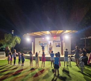 a group of children watching a man on a stage at Sporting Club Village in Mazara del Vallo +121 photos