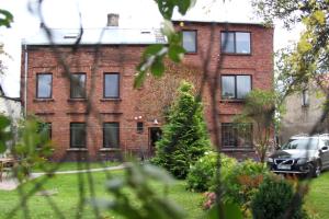 a brick building with a car parked in front of it at Seven Sisters Apartments with Self Check-In in Liepāja